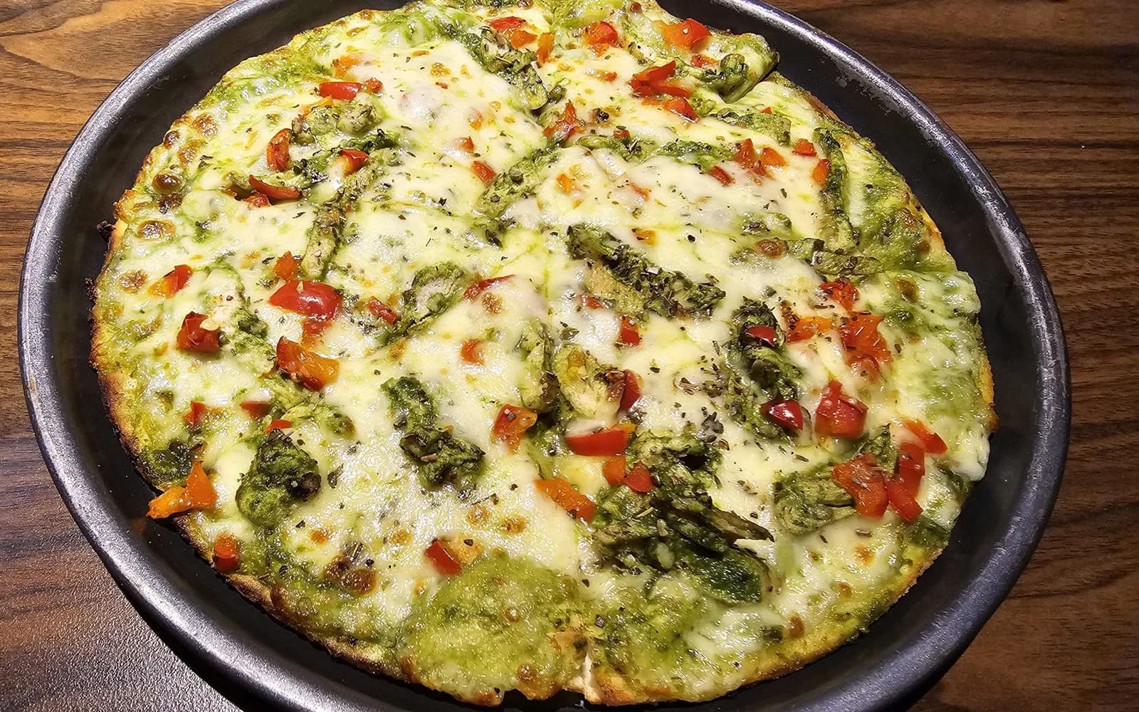 Chicken and herb pizza baked in a black pan