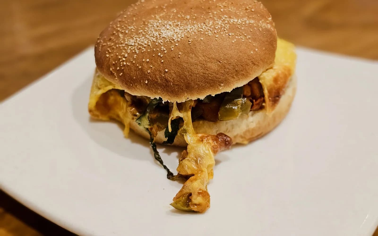 Crispy chicken burger in a sesame bun on a white plate