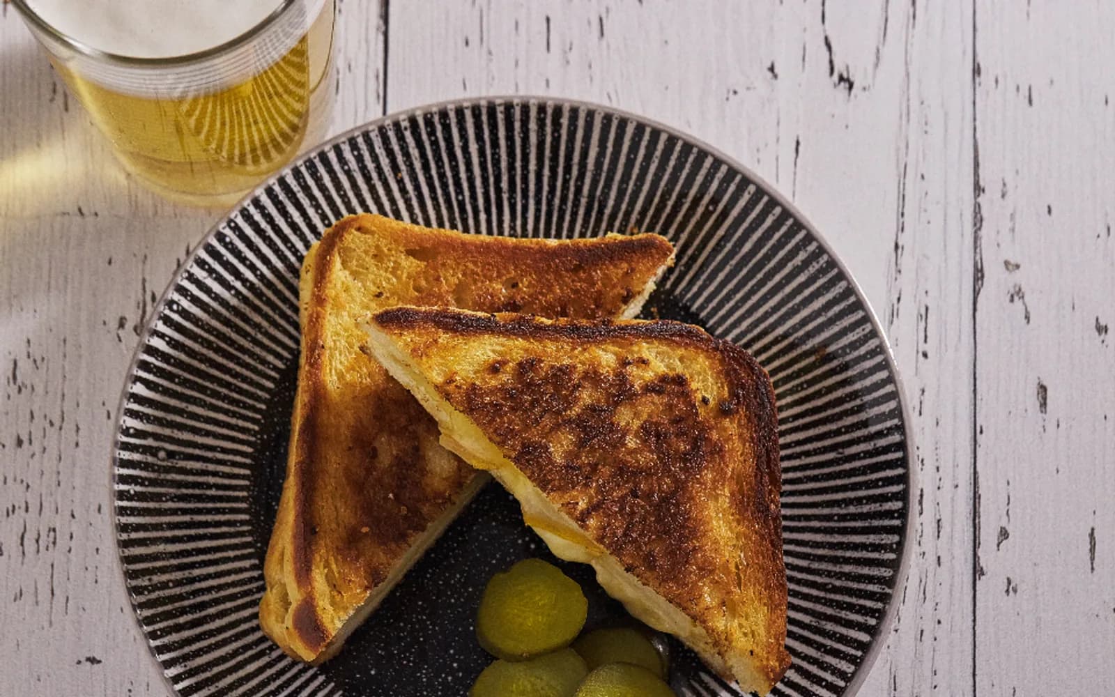 Grilled cheese toastie cut in half on a dark plate
