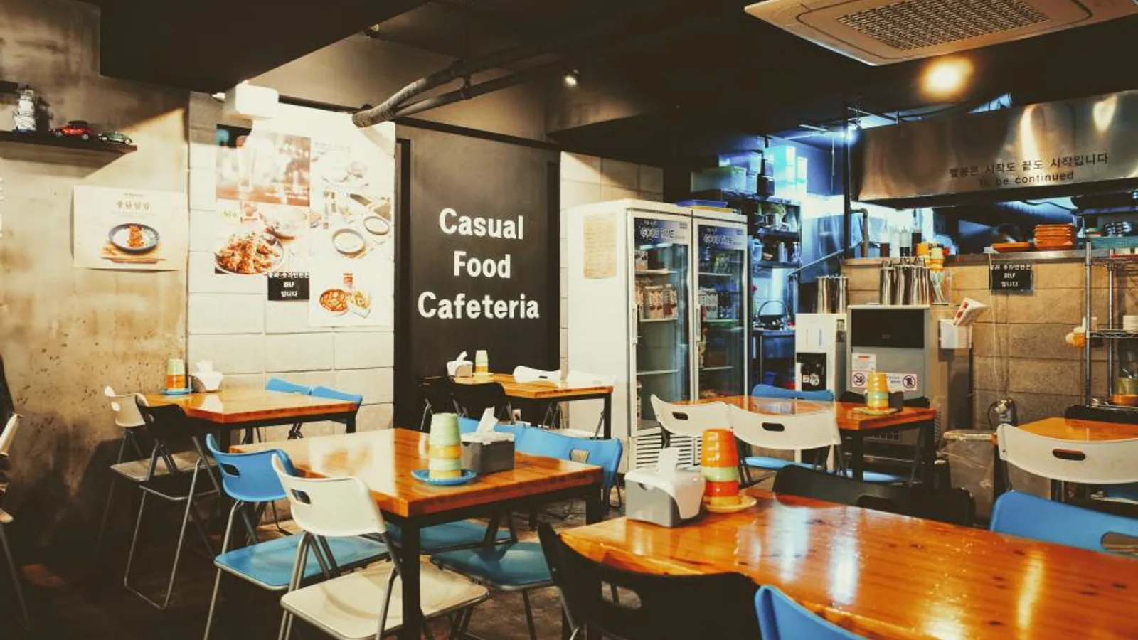Interior of a casual food cafeteria with tables and a menu board
